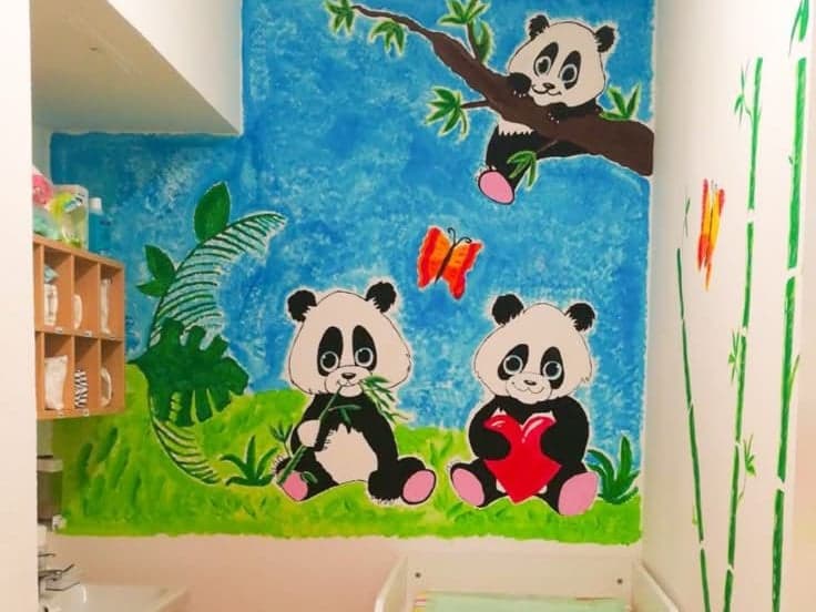 Gemaltes Wandbild mit drei Pandas über dem Wickeltisch