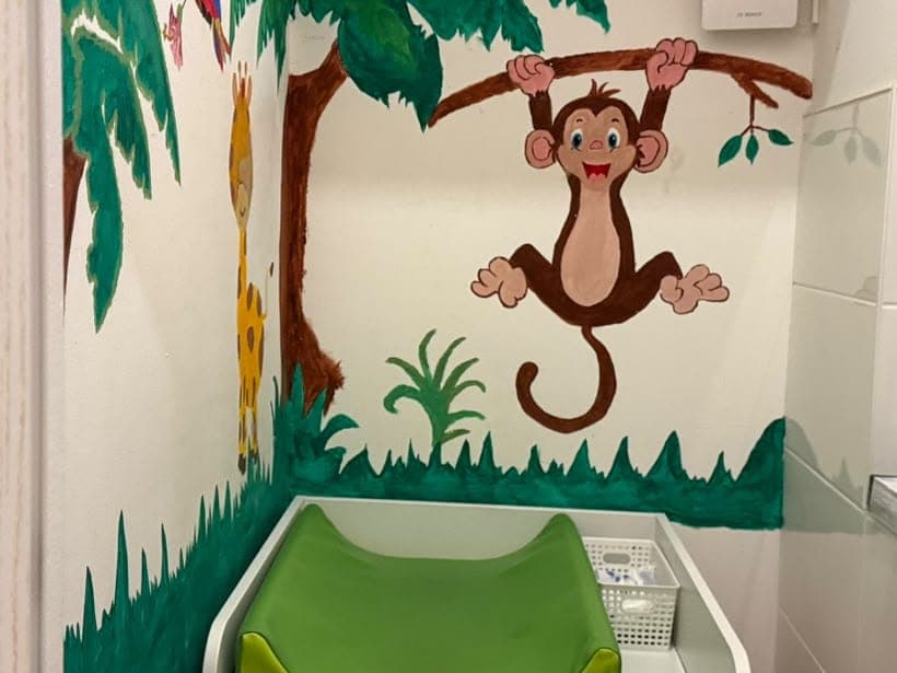 Wickeltisch vor einem gemalten Dschungel mit Affe und Giraffe